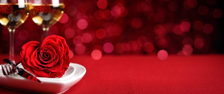 Herzteller mit Rose und Weingläsern zum Valentinstag